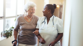 nurse walking with elderly woman