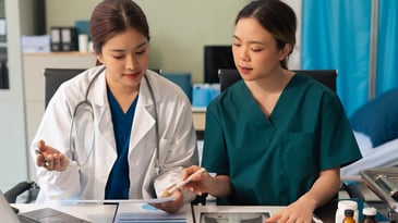 Two nurses discussing compliance issues in a skilled nursing facility
