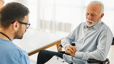 Nurse and senior resident in skilled nursing facility, consulting