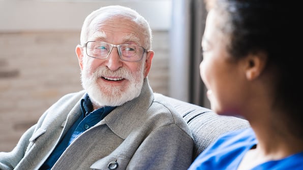 Senior man speaking with nursing home nurse