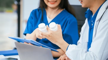 Two nurses holding medications, antipsychotics in nursing homes