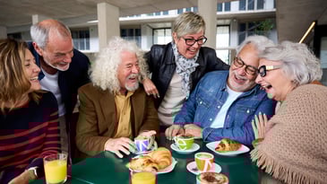 group of seniors around a table having fun and smiling