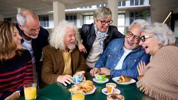 group of seniors around a table having fun and smiling