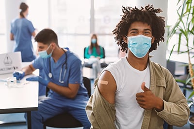 happy-black-guy-in-mask-showing-thumbs-up-after-va-2022-12-16-08-30-29-utc
