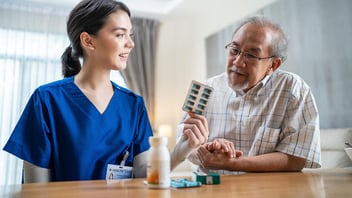 Nurse and senior look at medications, nursing home consulting