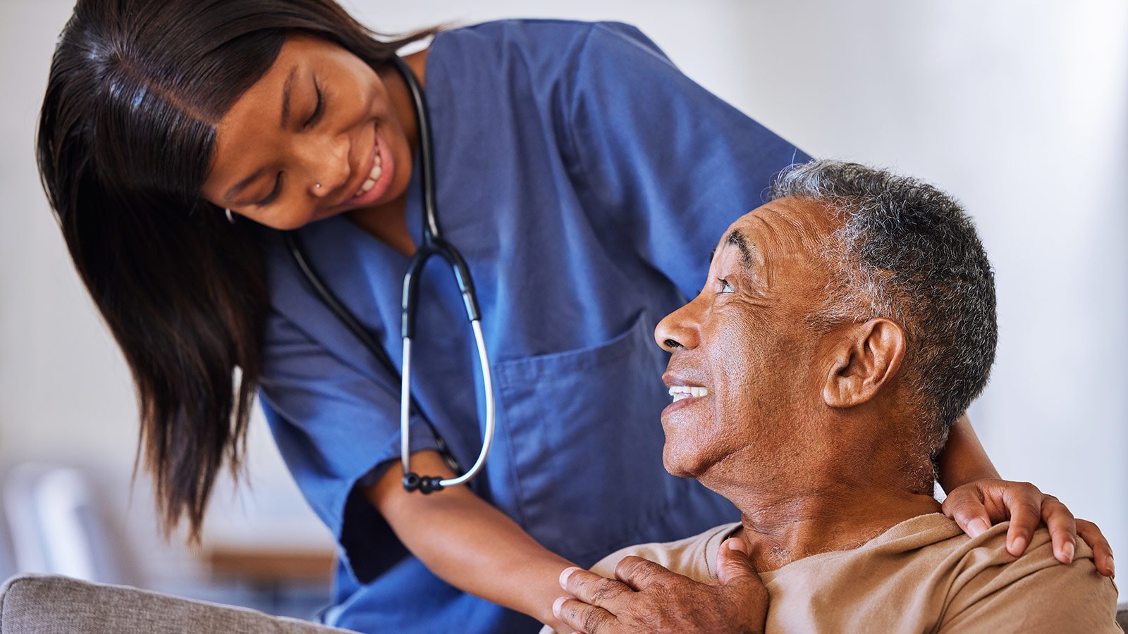 smiling nurse helping elderly patient