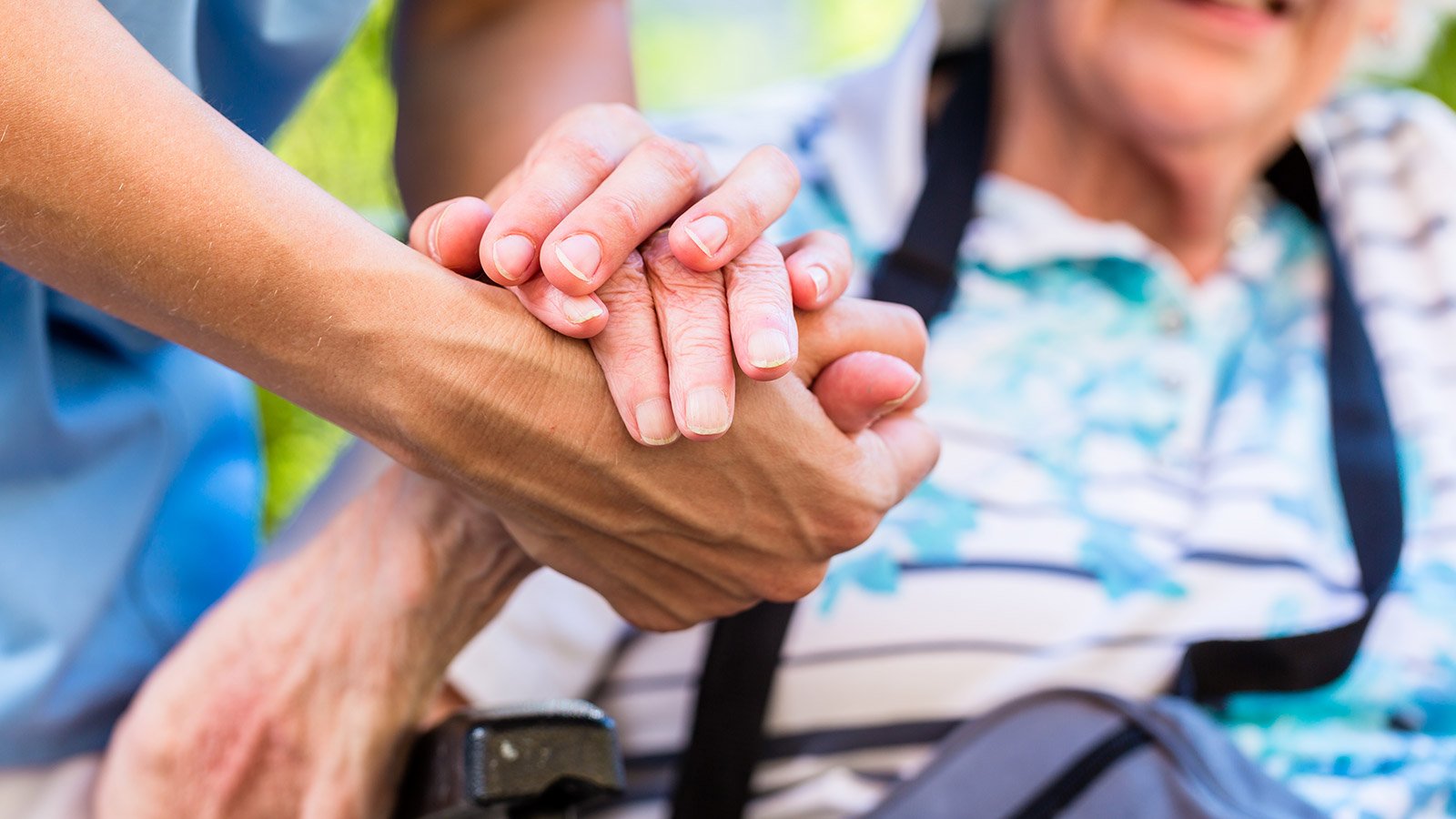 Nurse with senior woman holding her hand