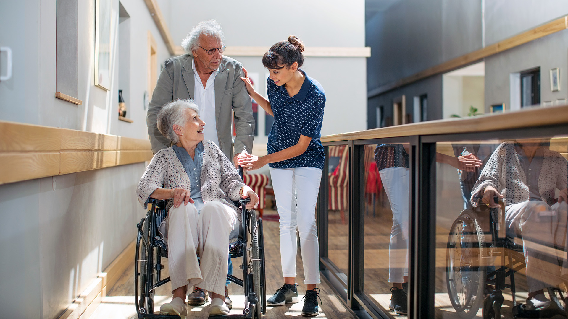 Nurse with two seniors in a hallway