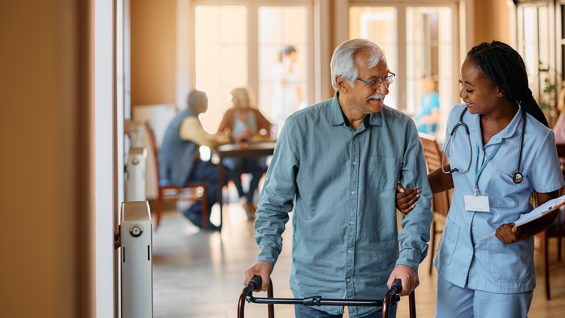 Female nurse helping older man with walker