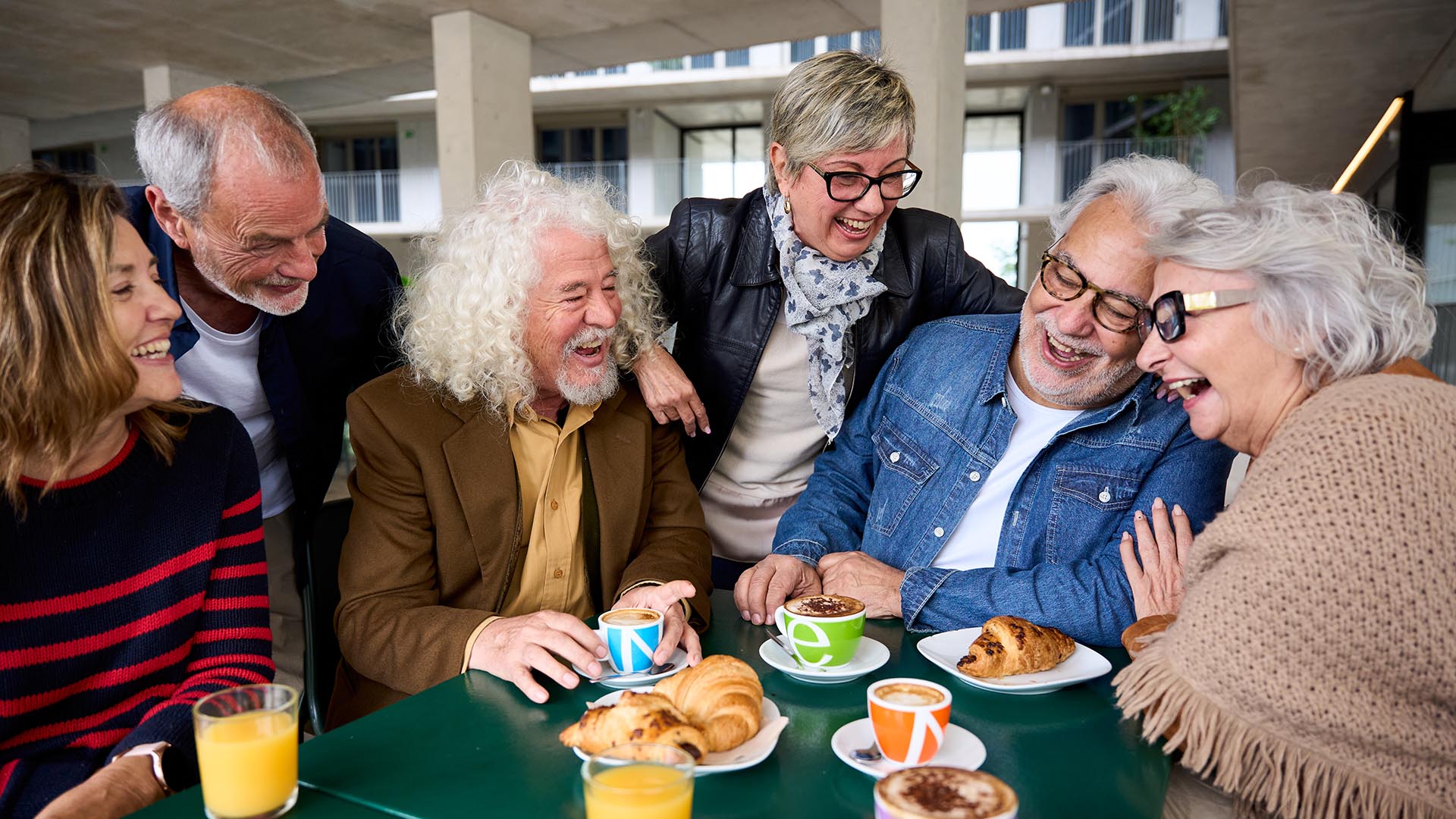 group of seniors around a table having fun and smiling