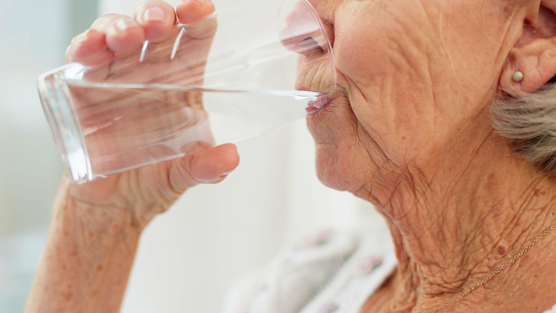 A senior woman take a drink of water