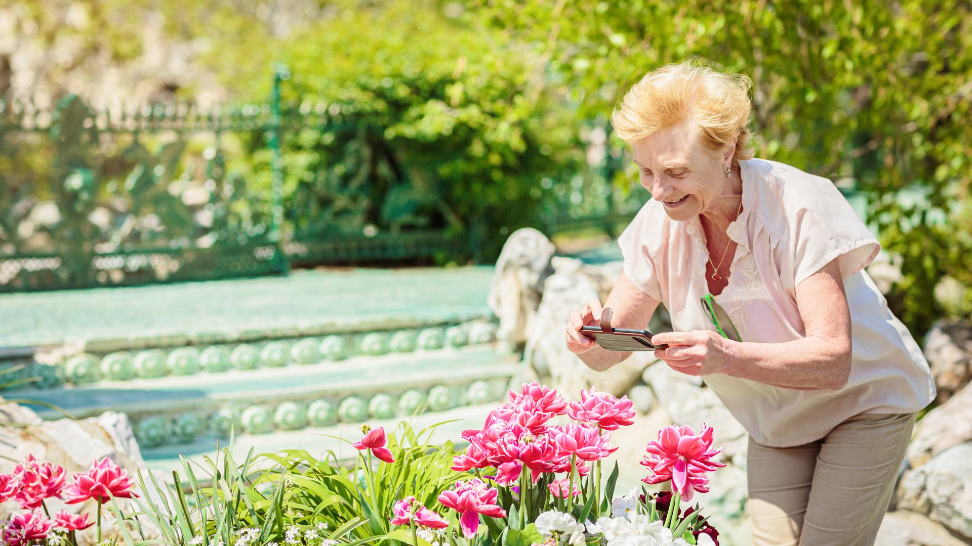 Senior woman sniffing flowers outdoors
