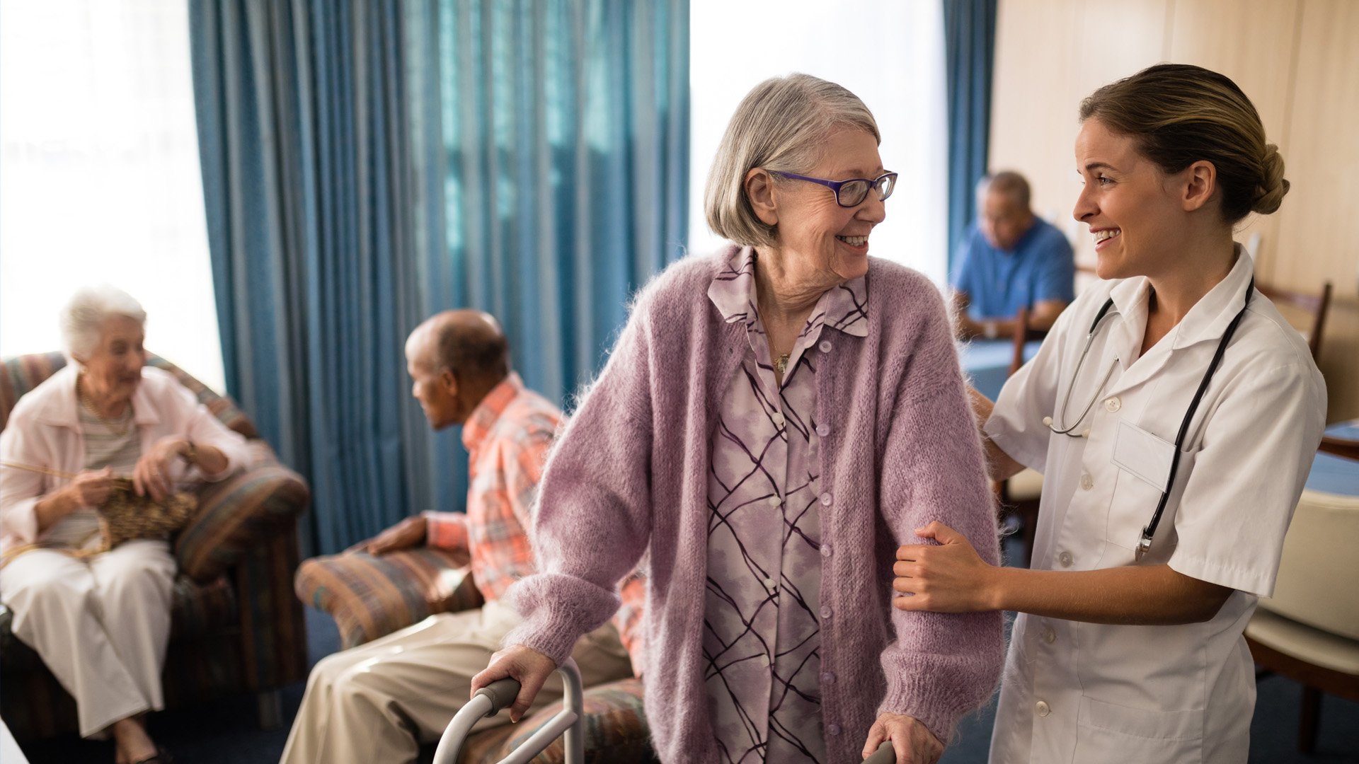 Nursing home nurse assists elderly woman