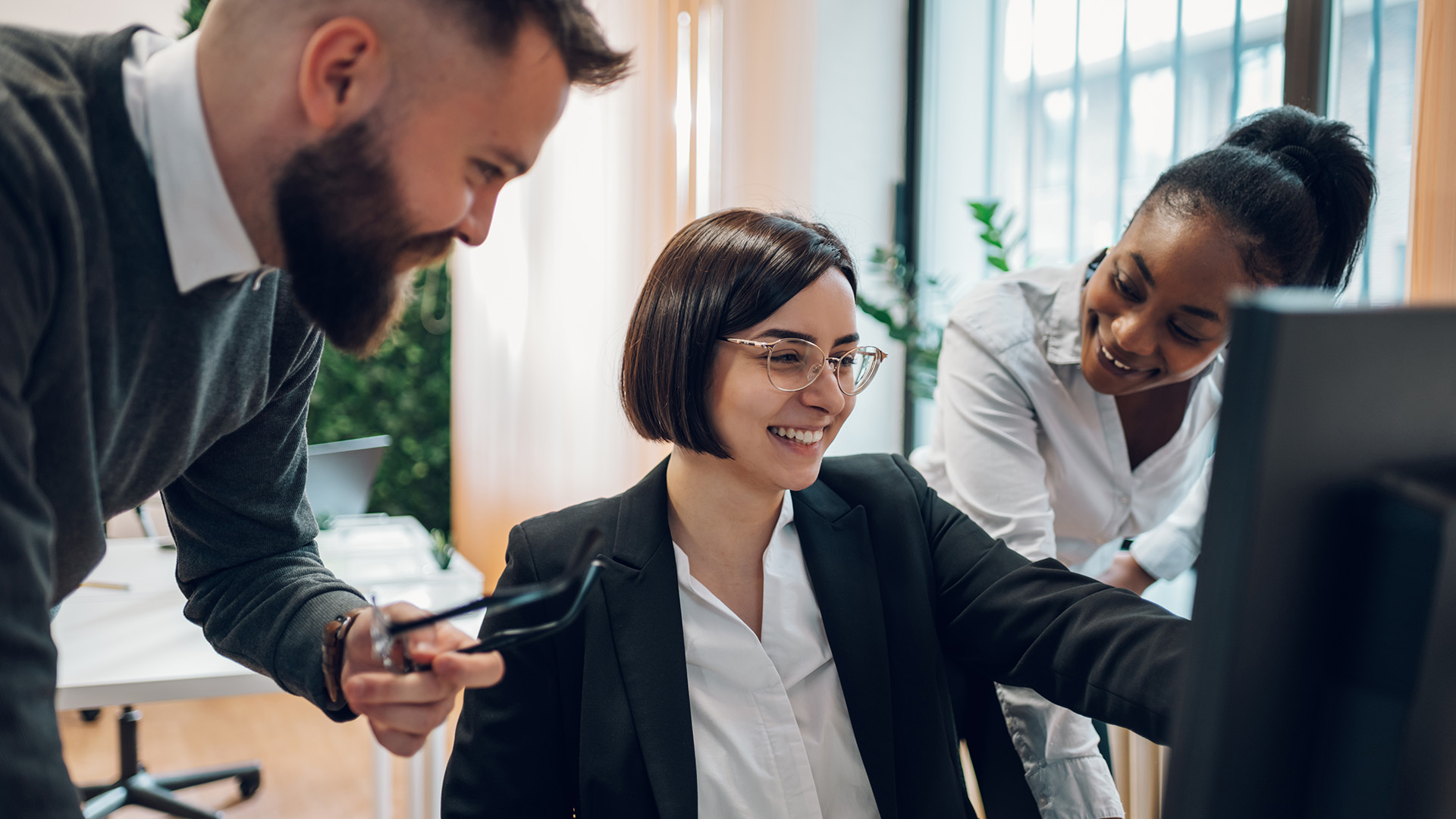 Group of professionals huddled around a computer