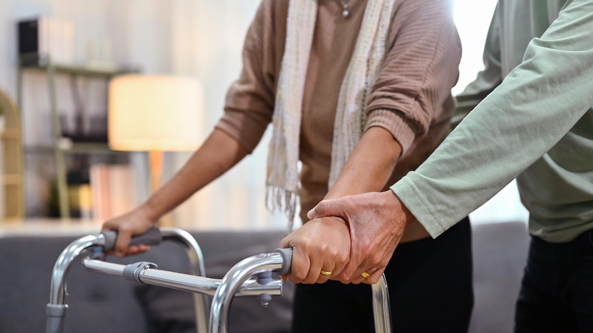 Nurse assists and elderly nursing home resident with walked, consulting
